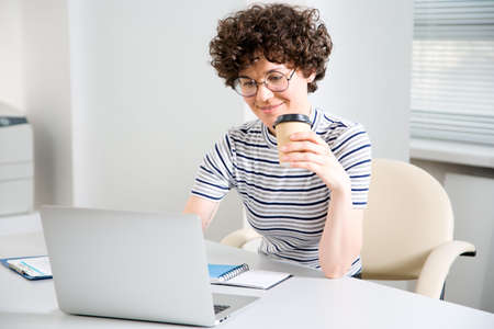 Portrait of a pretty business woman with glasses at workplace in officeの写真素材