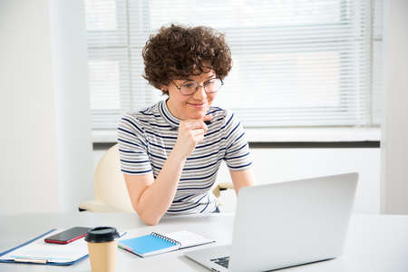 Portrait of a pretty business woman with glasses at workplace in officeの写真素材
