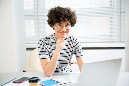 Portrait of pretty business woman looking at camera at workplace in an officeの写真素材