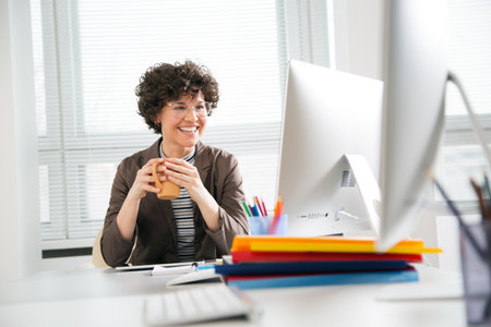 Portrait of a pretty business woman with glasses at workplace in officeの写真素材