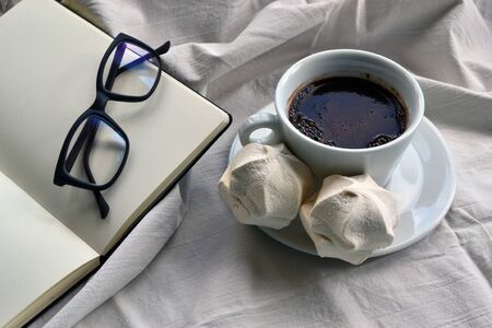 Coffee with dessert and a notepad with glassesの写真素材