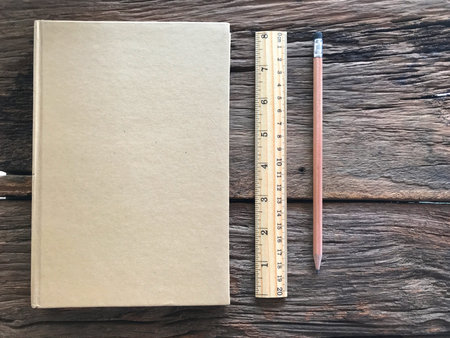 Old book and pencil on wooden table and the space for letters or symbols with the memo concept,...