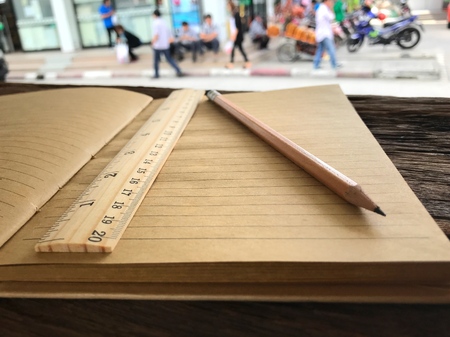 Old book and pencil on wooden table and the space for letters or symbols with the memo concept, time, past, ancient, handmade, vintage, learning, diaryの写真素材