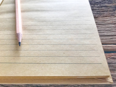 Old book and pencil on wooden table and the space for letters or symbols with the memo concept,...