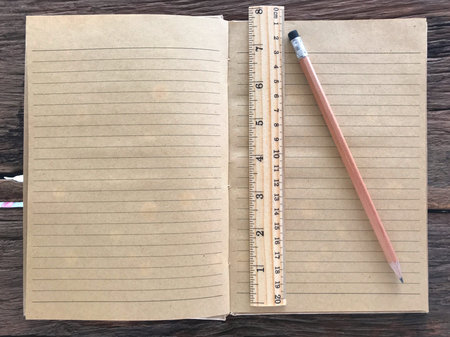 Old book and pencil on wooden table and the space for letters or symbols with the memo concept,...