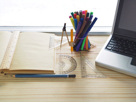 Computers, pencils, notebooks and drawing tools on wooden boards. Meaning of design work. New...