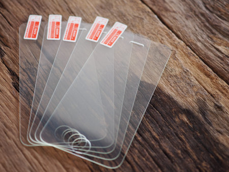 Glass screen protector on the old wooden board in the concept of protection and maintenance of...