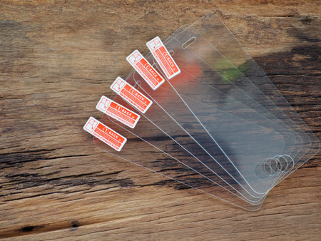 Glass screen protector on the old wooden board in the concept of protection and maintenance of...