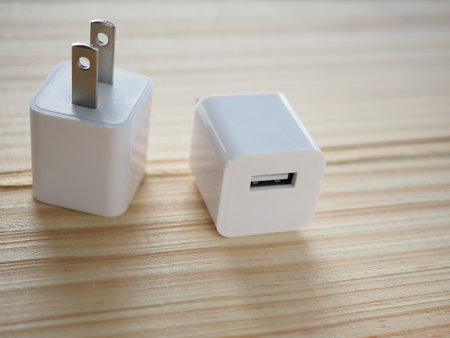 Usb white-cube charger on wooden board with technology and energy concept To facilitate And modern...