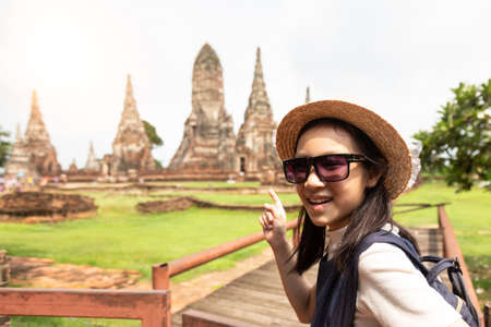 Cute happy smiling tourist girl,relaxing enjoying travelling at Wat Chaiwatthanaram is a Buddhist temple in the city of Ayutthaya Historical Park,Thailand, summer vacation,travel concept.の写真素材
