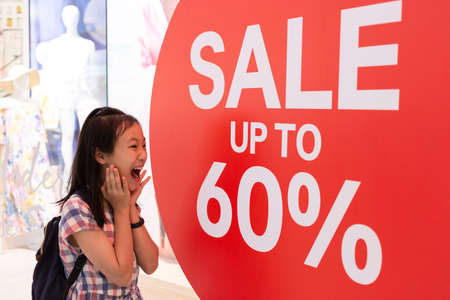 Photo shocked girl standing of shop windows with a sale,shocking priceの写真素材
