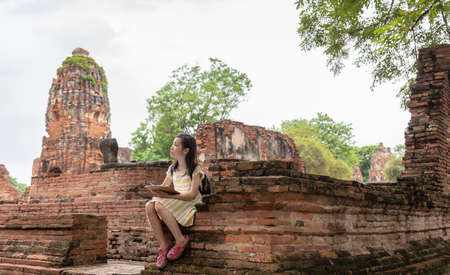 Asian cute girl relaxing outdoors while drawing,Student enjoy learning at historical, park,Wat Mahathat,Ayutthaya,Thailandの写真素材