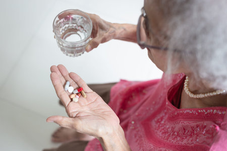 Asian elderly woman are taking and eating medicines and vitamins for help sick and healthy at...