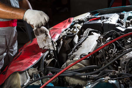 Auto mechanic checking oil,car repair serviceの写真素材