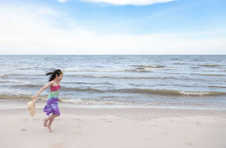 Happy little girl playing on the beach,summertime fun conceptの写真素材