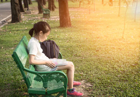 Asian girl reading a book in the parkの写真素材