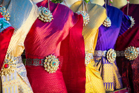 Vibrant traditional Thai silk dresses and accessories displayの写真素材