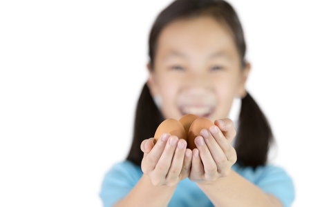 Happy asian girl holding an egg in her hands isolated on white background,eggs are useful,eat one...