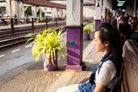Asian girl is sitting waiting for the parents to come back home in the train station,depressed girl,absent-mindedの写真素材
