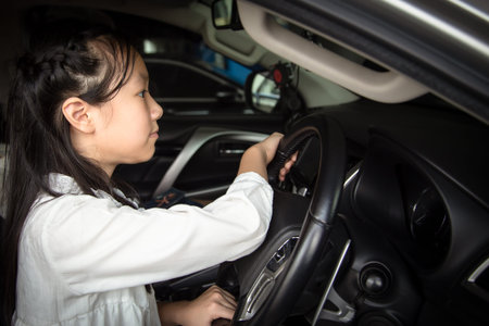 Asian little girl driving a car