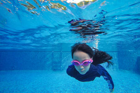 Happy asian girl swim and dive underwater, summer family vacation with child,relax,fun activityの写真素材
