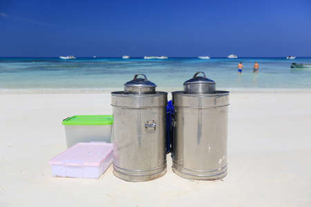 Stainless steel ice cream buckets and accessories on the beach,sea and blue sky backgroundの写真素材