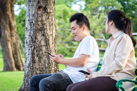 Asian couple,jealous woman with mistrust,noticing,peeking,young man holding mobile phone...