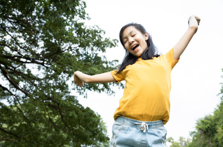 Happiness asian woman standing feel comfortable at park,smiling female teenage with stretching her...