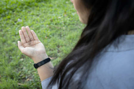 Sad asian woman with hairline problem hold loss hair in hand on green nature background,stressed female people with fallen hair on the palm after slick the hair back or scratch the head feel anxiousの写真素材