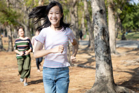 Healthy asian family,happy child girl have fun,enjoy game in nature outdoor park on summer,senior grandmother,daughter and granddaughter playing tag game,running joyful, holiday activitie,relaxationの写真素材