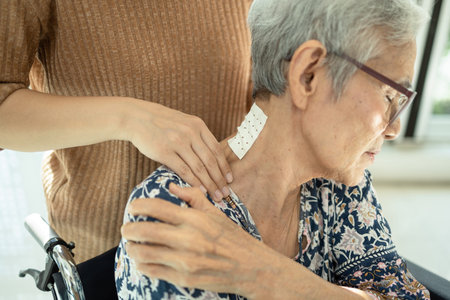 Asian senior mother have nerve pain,shoulder ache,neck pains,female caregiver or daughter massaging...