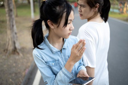 Distracted child girl looking at phone,addicted to playing games on mobile phone,crashed into adult...