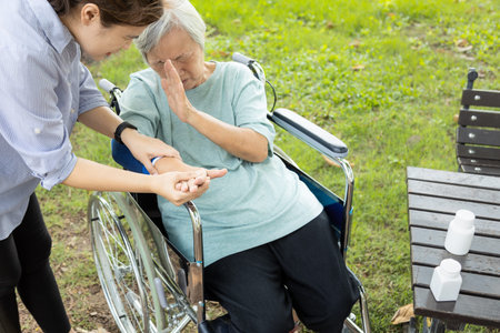 Injured asian senior woman wearing elbow support suffering from sore muscle,elbow joint arm...