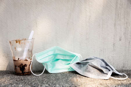 Litter of plastic  and surgical mask prevent the Corona virus, coronavirus 2019-nCoV,Influenza virus,throw trash in the floor,hazardous waste,infectious waste,risk of disease,spread of germ,の写真素材