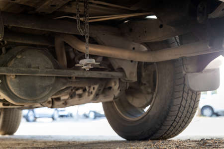 Spare tire wheel stored under the car were stolen,spare wheel has been lost,car missing tire,stolen tire in the parking car,concept of burglary insurance,theft,larceny,criminal,problems of junkieの写真素材