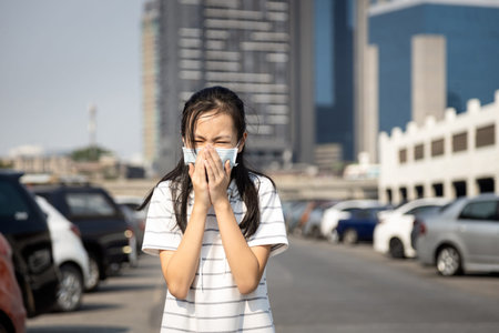 Sick asian child girl cough,sneeze wearing protective mask have severe allergic reaction to dust,air...
