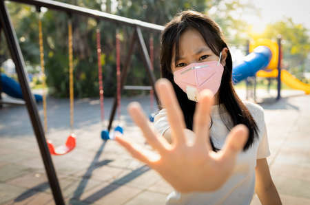 Asian child girl wearing protective medical mask,show stop gesture,handの写真素材