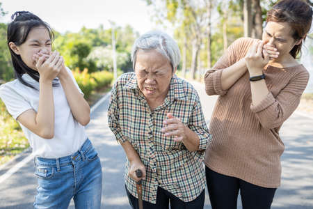Sick woman with fever,cough and sneezing without protection,air spreading germs,contagion of Covid-19 with a contaminated patient,risk symptoms of influenza,Coronavirus pandemic,respiratory infectionの写真素材