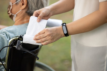 Hands of woman using tissue paper entwine handlebar of   wheelchair instead of touch her...