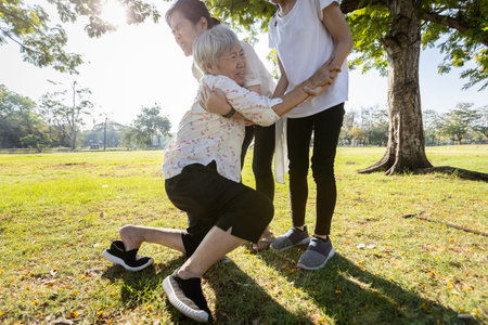 Female elderly was trying to stand up,asian daughter help,care,support her senior mother to stand up from ground after fell with vertigo,dizziness,old people in the accident slipped down while walkingの写真素材