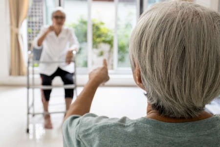 Asian senior women wear prevention medical mask talking by maintain distancing,protection infection of flu,Coronavirus,avoid Covid-19 pandemic,elderly people with maintain social distance for safetyの写真素材