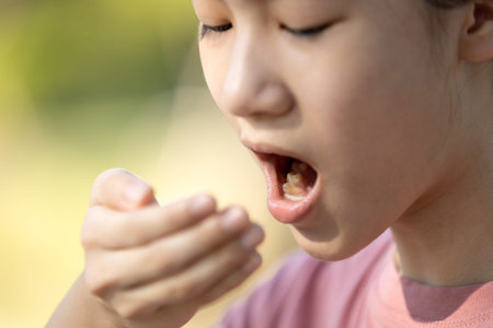 Child girl checking breath with her hand,woman doing a bad breath test after have breakfast,foul mouth from inside the tongue,teeth and gums,oral bacteria problems,halitosis,health care,dental conceptの写真素材