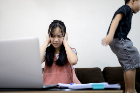 Asian child girl is using her hands to cover her ears from the loud voice,annoying noise from little...