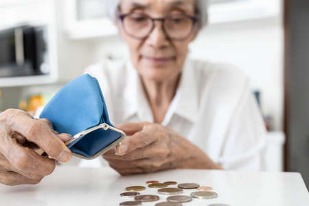 Happy smiling asian senior woman with her coins,old people with small change,female elderly don't have much money,don't want perfect life,but her have happiness,new normal lifestyle,sufficiency lifeの写真素材