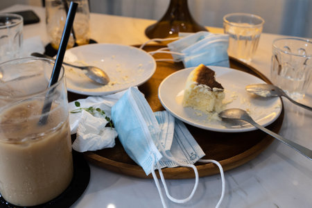 Infectious waste of medical masks,scraps of food,tissues on plates and used protective face masks...