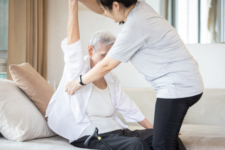 Assisting in dressing,asian female caregiver taking care of helping elderly patient get dress,chang...