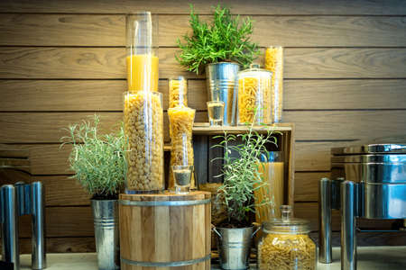Variety of raw dry pasta rigatoni, fusilli, penne, fettuccine, spaghetti, linguine and macaroni,Italian pasta in glass jars,set of many different pasta types in the kitchen,dining room or restaurantの写真素材
