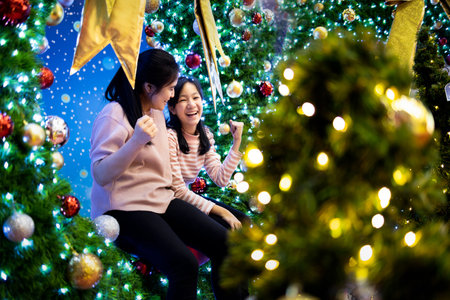 Happy asian family,beautiful mother and child girl are sitting at the Xmas tree,celebrating Christmas,loving mother and daughter enjoying,fun,festive Christmas,new year decoration,celebration conceptの写真素材