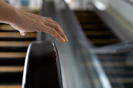 Close up,Hand of female with handrail of escalator,avoiding or not touching the handrail while using...
