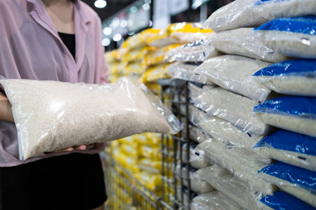 Close up of hands,Asian female consumer holding white rice,shopping dry food,girl buying jasmine rice in transparent plastic bag,choose raw rice products packed for sell at supermarket,food nutritionの写真素材